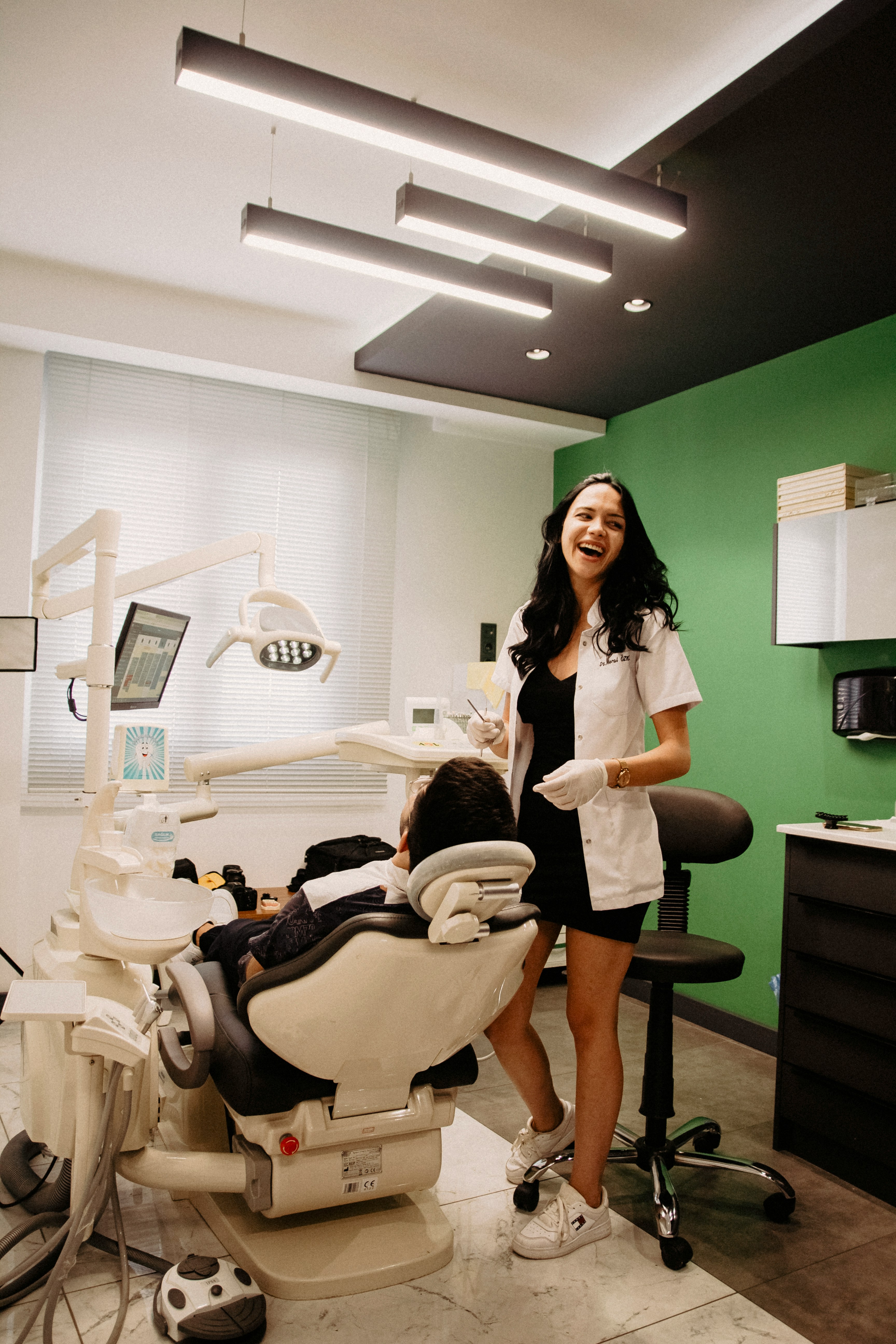 A dentist laughing with a patient in the chair